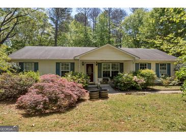 Charming ranch home with lush landscaping and a welcoming front porch at 1326 Harmony Grove Church Rd, Auburn, GA 30011