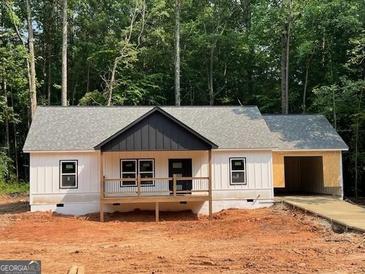 Charming single-story home with a welcoming front porch and an attached garage nestled amongst lush greenery at 22 Summer Ct, Carrollton, GA 30116