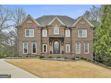 Magnificent brick home with a manicured lawn and elegant architectural details at 202 Firefly Ct, Peachtree City, GA 30269