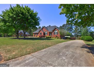 Charming brick home with a manicured lawn, mature trees, and a long driveway at 220 Edna Ruth Ln, Mcdonough, GA 30253