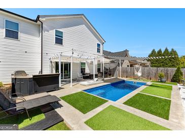 Beautiful backyard featuring a private pool, luxurious lounge area, and well manicured landscaping at 65 Hill Top Cir, Grantville, GA 30220