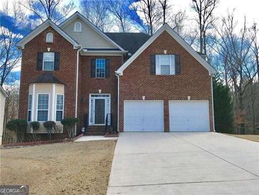 Charming two-story brick home with a two-car garage and well-maintained front yard at 3215 Rose Petal Ln, Powder Springs, GA 30127