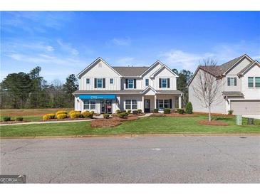 Charming two-story home with manicured lawn and inviting curb appeal on a sunny day at 284 Villa Grande Dr, Locust Grove, GA 30248