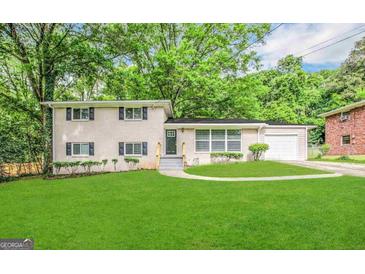 Charming two-story home with a well-manicured lawn and lush landscaping, complemented by a neutral-toned exterior at 2099 Yucca Dr, Decatur, GA 30032
