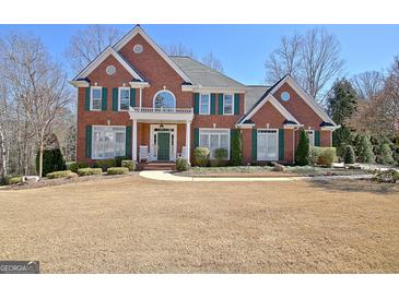 Stately brick home featuring manicured landscaping, green shutters, and a welcoming front porch at 319 Corrigan Trce, Peachtree City, GA 30269