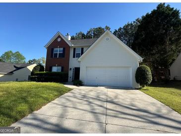Charming two-story home featuring a brick and vinyl exterior, a two-car garage, and a well-maintained front yard at 435 Cedarhurst Rd, Lawrenceville, GA 30045