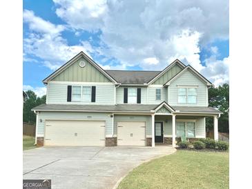 Charming two-story home with a three-car garage and well-maintained lawn at 9108 Alden Dr, Locust Grove, GA 30248