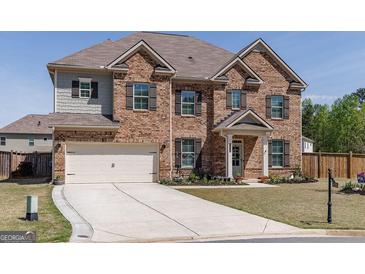 Charming two-story brick home with a manicured lawn and a spacious driveway at 7435 Ansley Park Way, Cumming, GA 30028