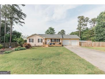 Charming single-story home with a well-maintained lawn, a front porch, and a two-car garage at 15 Pine Run Rd, Carrollton, GA 30116