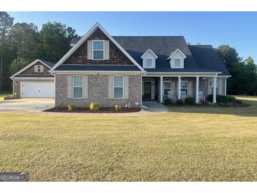 Charming brick home features an attached garage, inviting front porch with rocking chairs, and a well-manicured lawn at 30 Scouts Ridge Dr, Covington, GA 30016