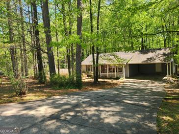 Charming home nestled among mature trees with a quaint front porch and convenient carport at 146 Highland Cir, Mcdonough, GA 30253
