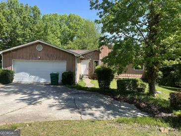 Charming home featuring a two-car garage, stone accents, and a well-maintained yard with mature trees at 1937 Young Rd, Lithonia, GA 30058