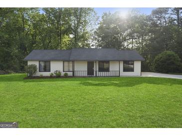 Charming single-story home featuring a well-manicured lawn and a classic design at 389 Rosser Rd, Mcdonough, GA 30252