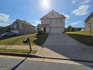 Two story house with a long concrete driveway and an attached garage at 495 Mcgiboney Ln, Covington, GA 30016