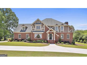 Stately brick home boasts a manicured lawn and a circular driveway, exuding curb appeal at 780 Birkdale Dr, Fayetteville, GA 30215
