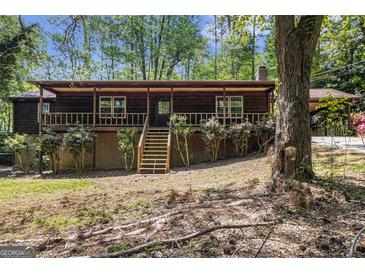 Rustic cabin-style home featuring a charming front porch and mature trees on a wooded lot at 20 King Pl, Stockbridge, GA 30281