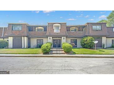 Traditional-style townhome with a meticulously maintained lawn and welcoming double-door entryway at 93 Rue Fontaine, Lithonia, GA 30038