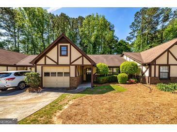 Charming home with Tudor-style accents, featuring a well-manicured lawn and attached garage at 335 Jeff Davis Pl, Fayetteville, GA 30214