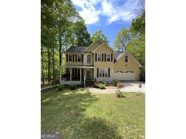 Charming two-story home featuring a front porch, attached garage, and well-maintained front yard at 5363 Forest Dr, Loganville, GA 30052