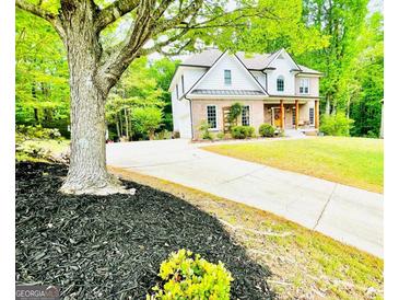 Beautiful brick and white home with a long driveway and mature trees at 2870 Willow Wisp Way, Cumming, GA 30040