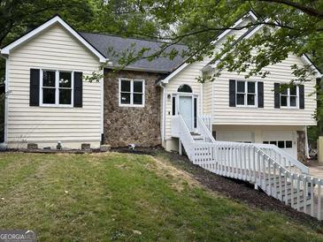 Charming split level home featuring stone accents, white trim, and a two-car garage at 5640 Rolling Oaks Dr, Cumming, GA 30040
