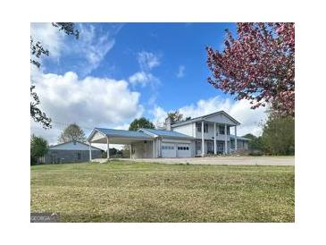 Inviting two-story home with a steel roof, covered parking, and charming curb appeal at 732 Sandhill Shady Grove Rd, Carrollton, GA 30116