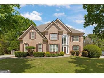 Charming brick two-story home with manicured lawn and mature trees, perfect for suburban living at 891 Berryman Pl, Lawrenceville, GA 30045