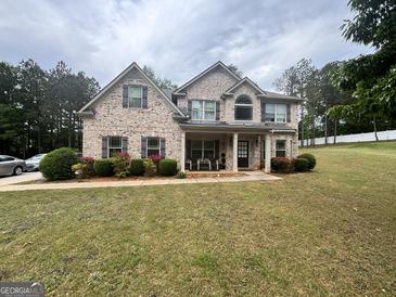 Beautiful, two-story brick home with a well-manicured lawn and inviting front porch at 441 Lilywood Dr, Mcdonough, GA 30253
