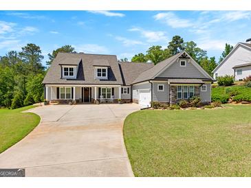 Charming home with a lush green lawn, a welcoming front porch and an extended driveway at 266 Blue Point Pkwy, Fayetteville, GA 30215