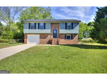 Charming brick home with a well-manicured lawn and a two-car garage, perfect for Gathering living at 130 Belmont Farms Dr, Ellenwood, GA 30294