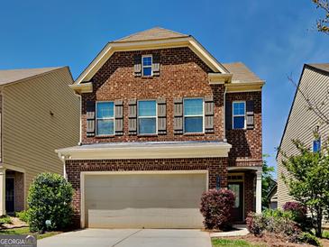 Charming two-story brick home with a two-car garage, manicured lawn and beautiful landscaping at 3733 Upland Dr, Mcdonough, GA 30253