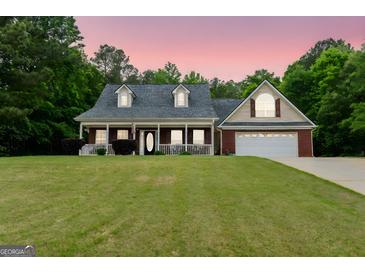 Charming single-story home featuring a brick facade, inviting porch, and attached two-car garage at 563 Deadwood Trl, Locust Grove, GA 30248