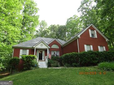 Charming single-Gathering home featuring brick facade, dormer window, and landscaped front yard at 25 Lake Charles Ct, Covington, GA 30016