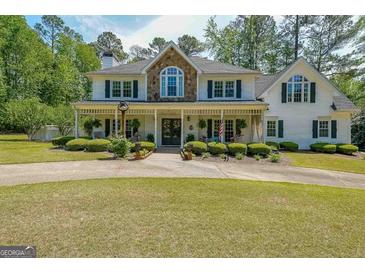 Charming two-story home with a welcoming front porch and well-manicured landscaping at 12 Blackfoot Trl, Sharpsburg, GA 30277