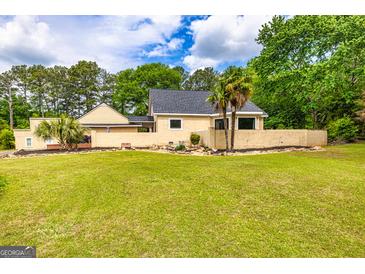 Spacious home featuring a well-manicured lawn and mature trees at 26 Cannongate Rd, Sharpsburg, GA 30277