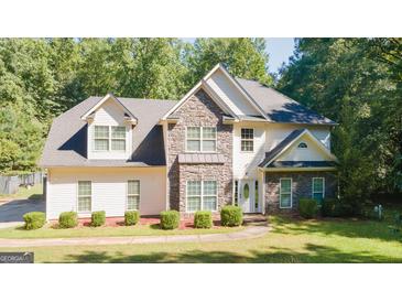 Beautiful home featuring stone and siding exterior, manicured lawn, and mature trees at 1231 Hillview Rd, Hampton, GA 30228