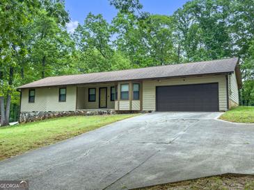 Quaint single-Gathering home with a long driveway, attached garage, and well-maintained lawn at 110 Thompson Blvd, Stockbridge, GA 30281