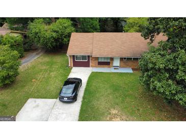 Charming single-story home featuring a brick facade, well-maintained lawn, and a private driveway with parking at 7336 Howard Cir, Jonesboro, GA 30236