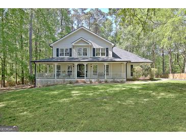 Charming two-story home boasts a full front porch and mature landscaping at 110 Greenridge Ct, Fayetteville, GA 30215