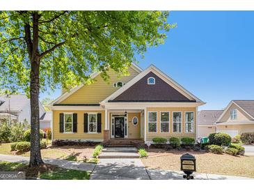 Charming home with yellow siding, black shutters, and a well-maintained front yard at 140 Campaign Trl, Fayetteville, GA 30214