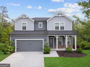 Charming two-story home with a covered porch, two-car garage, and manicured lawn at 1953 Azure Grove Ct, Marietta, GA 30008