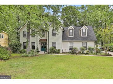 Charming two-story brick home with a well-manicured lawn and mature trees in a desirable neighborhood at 215 Calgary Dr., Peachtree City, GA 30269