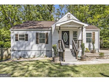 Charming one-story home featuring white siding, brown shutters, and a welcoming front porch at 1858 Ridgeland Dr, Decatur, GA 30032