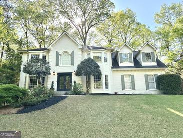 Beautiful painted brick home with a manicured lawn and mature trees at 160 Hialeah Way, Roswell, GA 30075
