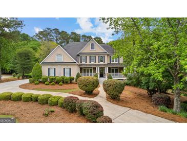 Stunning two-story home featuring a welcoming front porch and lush landscaping at 105 Riviera Ct, Fayetteville, GA 30215
