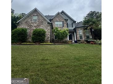 Beautiful brick home with well-manicured lawn and mature landscaping at 374 Persimmon Dr, Sharpsburg, GA 30277