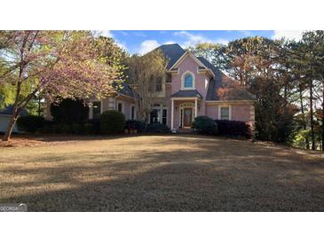Charming two-story brick home with mature trees and a well-manicured lawn at 8040 Classic Dr, Jonesboro, GA 30236
