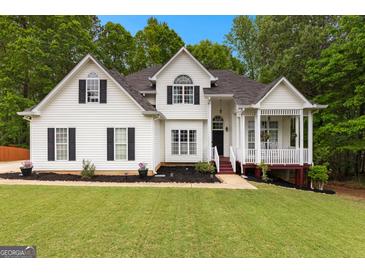 Charming two-story home featuring a manicured lawn, mature trees, and inviting front porch at 190 Ridgecrest Dr, Fayetteville, GA 30215
