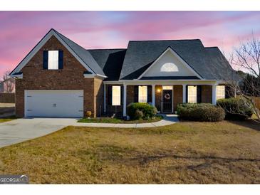 Charming brick home featuring a well-manicured lawn and inviting entrance with a wreath-adorned door at 3226 Puritan Way, Mcdonough, GA 30252