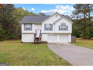 Charming two-story home featuring a well-manicured lawn and a double garage, perfect for Gathering living at 470 Old Griffin Rd, Hampton, GA 30228